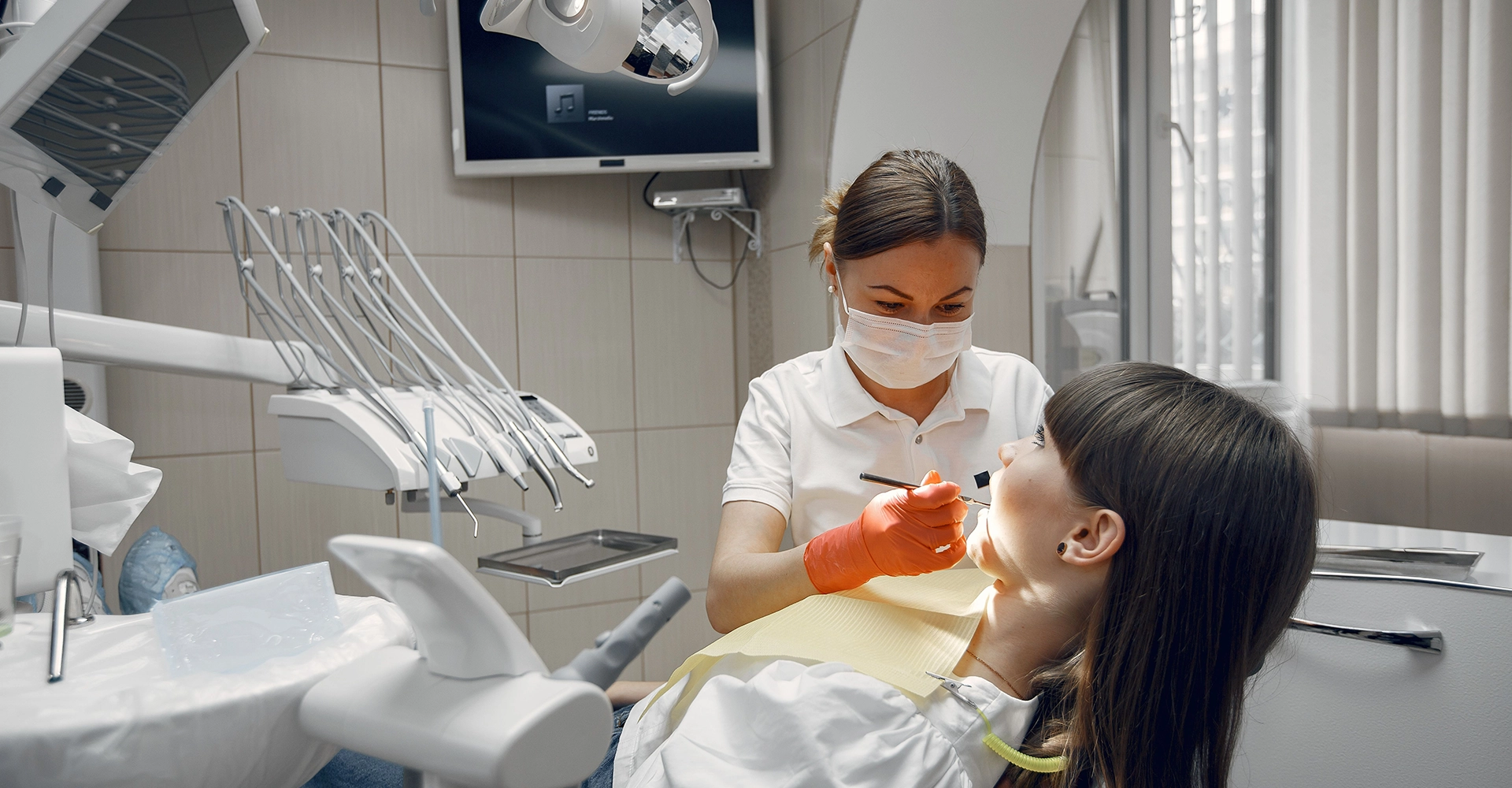 Dentista atendiendo a una paciente en una clínica moderna